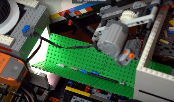 En av de mer praktiske oppgavene som Daniel West kjempet med, var å få flyttet Lego-klossene slik at de kunne skannes én om gangen. Løsningen ble et vibrasjonssystem drevet av en ultrarask Lego-motor. <i>Foto:  Youtube/Daniel West</i>