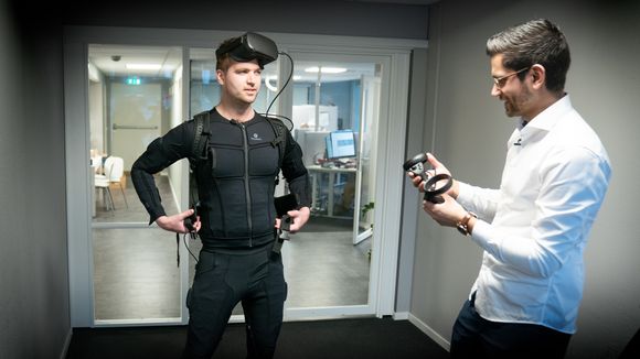 Christoffer Thambirajah viser reporter Mathias Klingenberg hvordan VR-systemet fungerer. <i>Foto: Eirik Helland Urke</i>