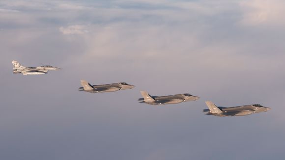 Et F-16B (toseters) fra den nå nedlagte 338 skvadron møter de tre første F-35A på vei til Ørland i november 2017. <i>Foto:  Helge Hopen / Forsvaret</i>