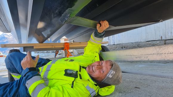 Frank Ole Bonsaksen i selskapet Green Fjords viser oss foilen som spenner mellom kjølene i det karbonfiberstøpte skroget til den elektrisk dreven båten. <i>Foto:  Odd Richard Valmot</i>