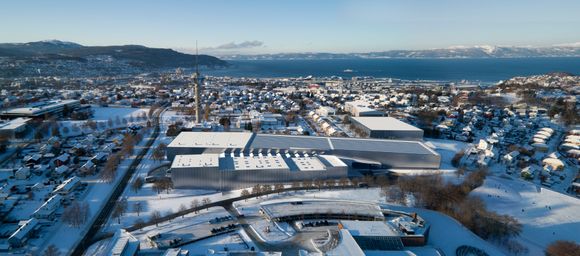 Fugleperspektiv av det nye marintekniske senteret på Tyholt med det kjente tårnet og Trondheimsfjorden i bakgrunnen. Ocean Space Centre, <i>Illustrasjon:  Snøhetta</i>