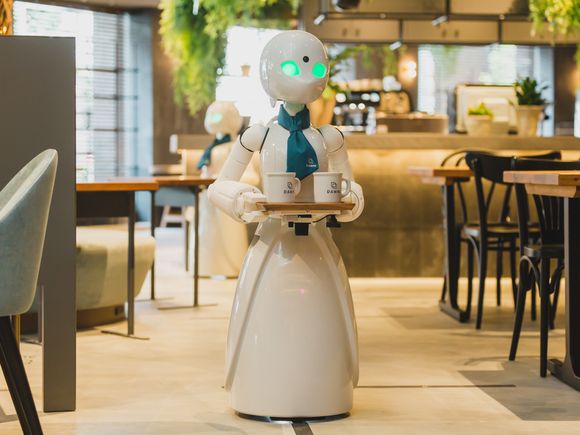 Alter-ego robot OriHime-D serverer mat til gjestene. Den fjernstyres av mennesker som av ulike grunner ikke kan forlate hjemmene sine. <i>Foto:  Dawn Avatar Robot Cafe</i>