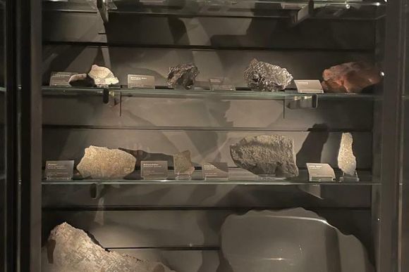 Her er et utvalg av meteorittene som er stilt ut på Naturhistorisk museum. Mange av dem er polert, kuttet eller kjemisk behandlet slik at du ser det spesielle mønsteret av jern og nikkel. Dette mønsteret dannes bare inne i svært store og tunge ting, som planeter. <i>Foto:  Elina Melteig/UiO</i>