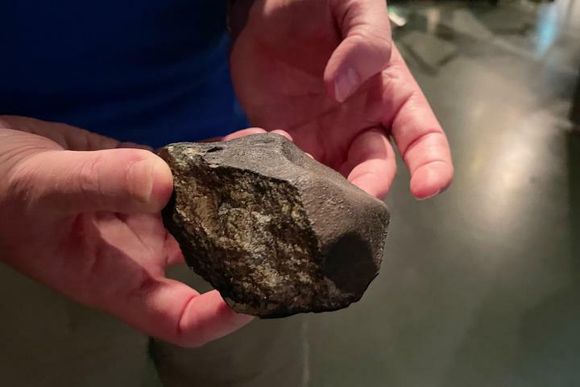 De fleste meteroritter har en skorpe ytterst. Den trenger ikke være jevn, og denne meteoritten har en skarp flate der en bit har brukket av. <i>Foto:  Elina Melteig/UiO</i>