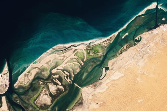 Et satellittbilde viser Siniyah Island i Umm al-Quwain, De forente arabiske emirater, der arkeologer nylig har funnet restene fra den eldste perlebyen som er funnet hittil. Den stammer fra slutten av 600-tallet. <i>Foto:  Planet Labs PBC</i>