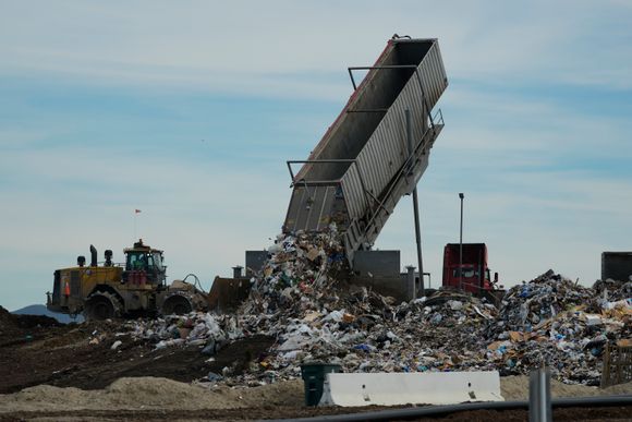 Søppel helles ut på en avfallsplass i Chula Vista i California. Delstaten ligger ikke an til å nå sitt mål om kildesortering for å holde organisk avfall unna avfallsplassene. Mat og annet organisk avfall på søppelplasser fører til utslipp av den kraftige klimagassen metan <i>Foto:  Damian Dovarganes / AP / NTB</i>