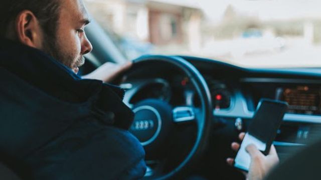 Nordmenn i bilkø kikker på mobilen og irriterer seg over andres mobilbruk