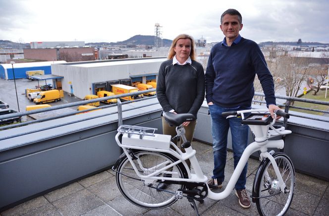 Prosjektleder for elbysykkelen, Randi Markvardsen og administrerende direktør, Stein Racin Grødem, på terrassen utenfor lokalene til Forus Næringspark, midt i næringsområdet. De viser fram årsaken til at de nå har bremsespor i teppet på kontoret.