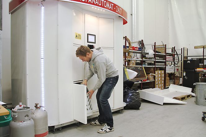 Når døren åpner seg setter han den tomme beholderen inn. Etter at den er scannet og funnet i orden åpner nok en dør seg, og kunden kan forsyne seg med en full gassbeholder.