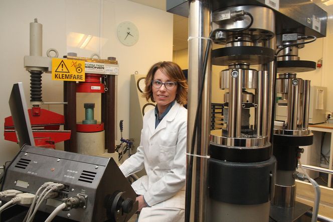 Kine Buchholdt Jonassen med utstyret for å teste hvor mye vertikalt trykk ulike typer betong tåler.