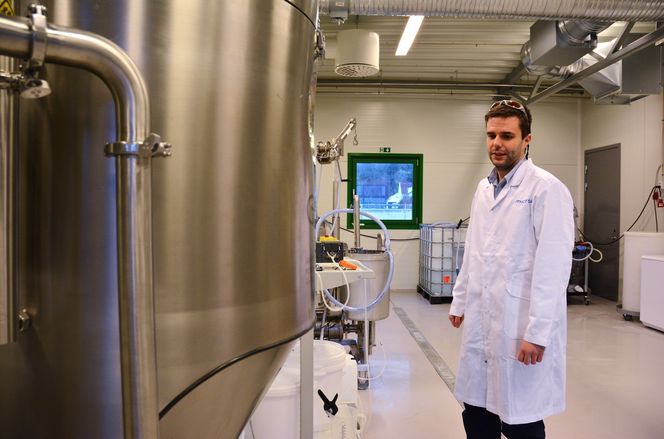 Produksjon- og teknologiansvarlig Lars Dahle forklarer hvordan de fjerner vannet fra algeproduktet. Siste steg er den store tanken foran ham, spraytørkeren.