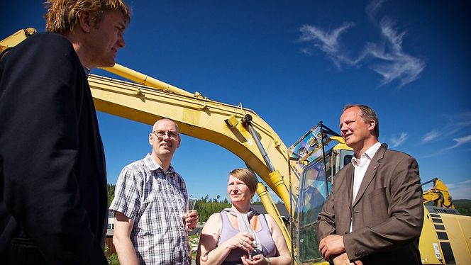 Samferdselsminister Ketil Solvik-Olsen (t.h.) startet sprengingen av tomten til smarthuset. I bakgrunnen kjøperne: Jens og Jytte Dein.