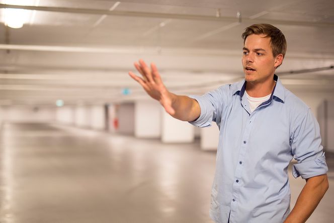 Daglig leder for Profesjonell Bygg Tjeneste, Magnus Leirfall, viser hvilke deler av garasjeanlegget som er behandlet med Titandioksid.