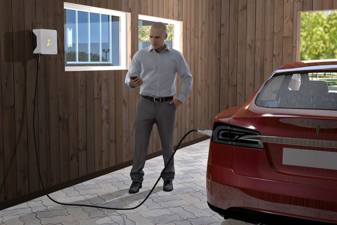 KORTERE LADETID: Zaptecs transformator (boksen på veggen) kan blant annet redusere ladetiden for elbiler. Mange har tre kW i garasjeladeren, noe som betyr at en Tesla Model S er fulladet på rundt 30 timer. Zaptecs transformator sørger for 11 kW, noe som kan redusere ladetiden til rundt ti timer.
