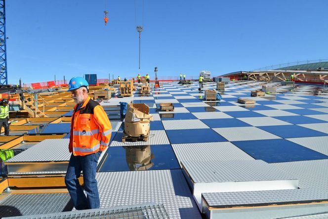 Gardermoens nye tak. Både hovedbæring og sekundærbæring er i stål. Limtre­kassetter er lagt ned mellom sekundærbæringene. Variasjonen mellom stål og glass gir en sjakkbretteffekt.