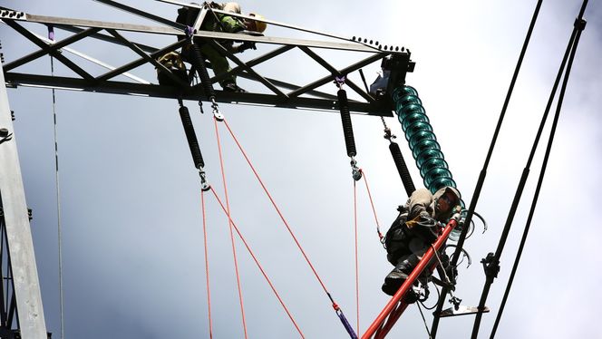 Høyspenning: Uten at spenningen skrus av legger Aleksander Mæhre fra NTE Entreprise på nye isolatorskåler for linjen skal kunne oppgraderes fra 300 til at 420 kV.