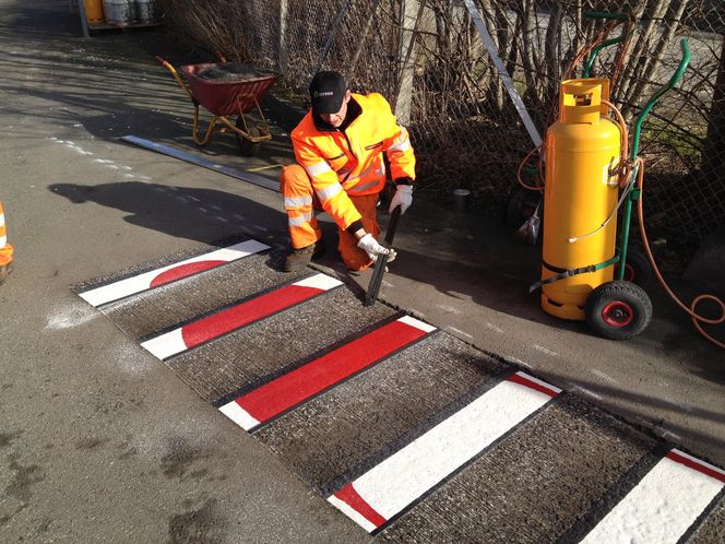 Striper av prefabrikert termoplast legges ned i sporene.