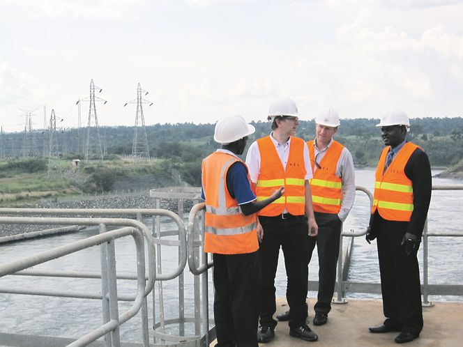 HJELPER: Statnett hjelper til med å bygge ut kraftnettet i Uganda. På bildet fra Bujagali-kraftverket ved Nilen, som ble satt i drift i vår, ser vi fra venstre Douglas Twinamatsiko fra kraftverket, Gunnar Løvås og Lars Teigset fra Statnett, og Kenneth Otim fra UETCL. FOTO: Statnett