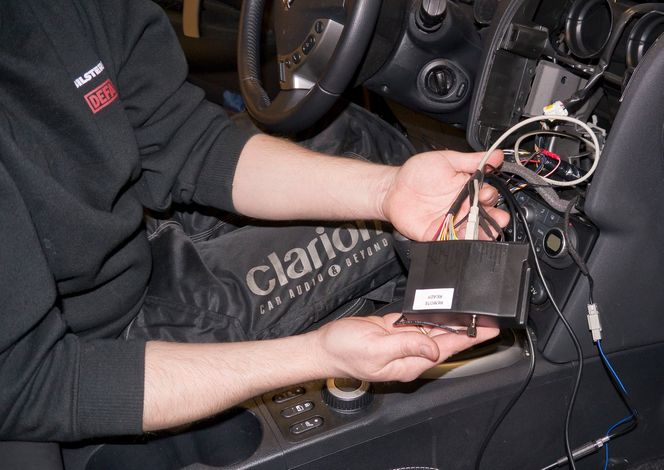 DAB-radioen: Verksmester Erik Monahan fra Oslo Bilstereo har koblet til DAB-modulen og er klar til å dytte den inn i dashbordet. Legg merke til USB-kabelen som ble trukket frem over pedalene og som kan brukes til å oppgradere radioen i fremtiden.