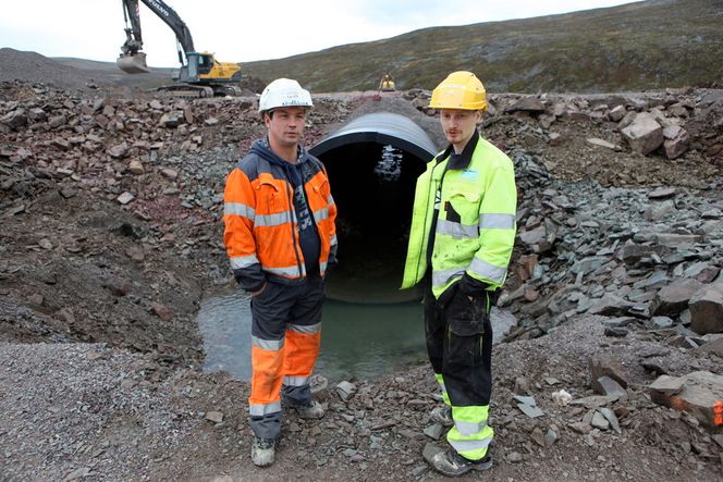 I stikkrenna er det lagt rund stein i bunnen. Ørreten liker ikke sprengt stein. Fagfolkene mener at fisken kanskje vil gyte under veien. Veiarbeiderne Bengt Pedersen (t.v.) og Chris Robert Aslaksen fra Tana har lite tro på det, de mener at den første vårflommen vil ta med seg steinhaugen.