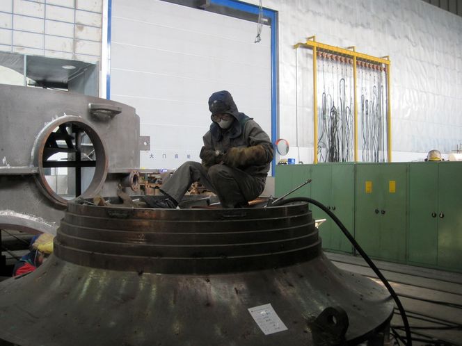 MADE IN CHINA: En kinesisk arbeider fikser på utstyret, før han dykker tilbake ned i jobben.