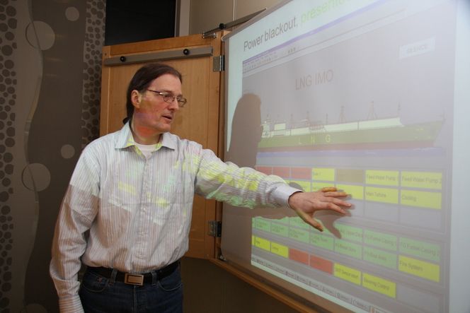 ALARMEN GÅR: Geir Hasnes viser grupper med alarmer. Grønn betyr at alt er OK. Gul betyr alarm og rød kritisk alarm. Prosjektet har tegnet et fiktivt LNG-skip for å demonstrere prinsippene.