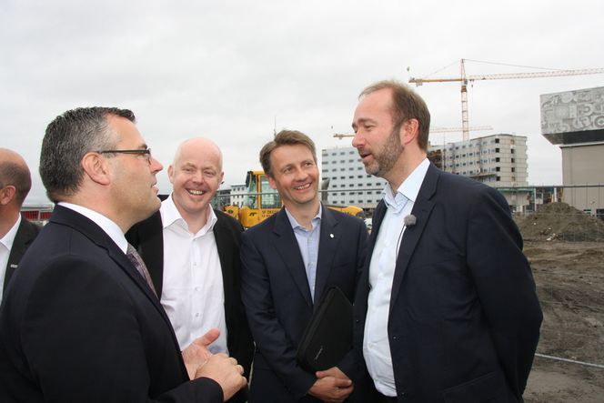 ENTUSIASME: Kyrre Olaf Johansen, Ole Gustavsen og Jørgen Rostrup i ivrig diskusjon med næringsminister Trond Giske ved tomten der det nye plusshuset skal bygges.