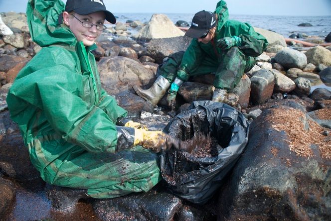 Frivillige RENSKER: Jeanette Aubert og Therese Kronstad i WWF slet i timesvis med å ta opp illeluktende oljemasse. (Foto: WWF)