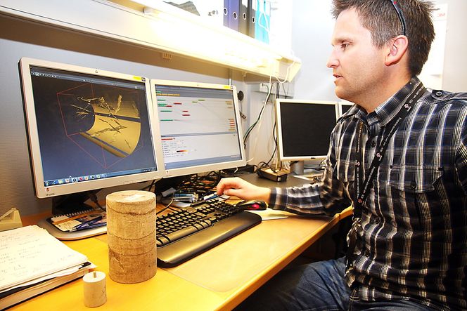 Innblikk: Statoil-forsker Lars Rennan med steinprøver som røntgenfotograferes. 3D-bildet på skjermen viser sprekker i den minste steinen. Foto: Tore Stensvold