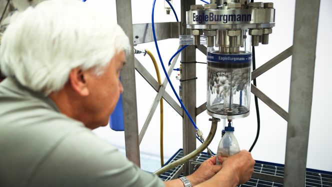 Jon Baklien sprøyter inn eksosblandet vann i separatoren. Ut kommer ren luft. Foto: Eirik Helland Urke