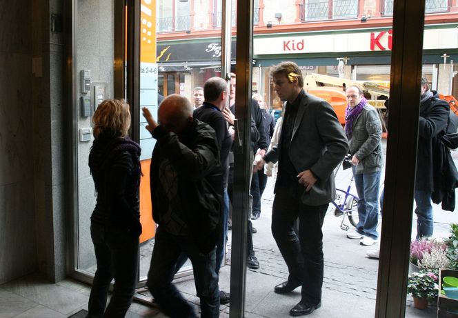 Flere personer som trolig er ansatte i Fast valgte å dekke for ansiktet på vei inn i lokalet.
