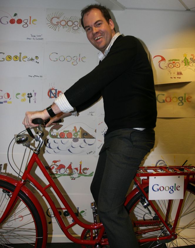 Googles lokaler har mengder av håndtegnede logoer hengende på veggene i selskapets lokaler, mange av dem tegnet av barn. Her demonstrerer Knut Magne Risvik Googles interne sykkel. Bilde: Marius Jørgenrud