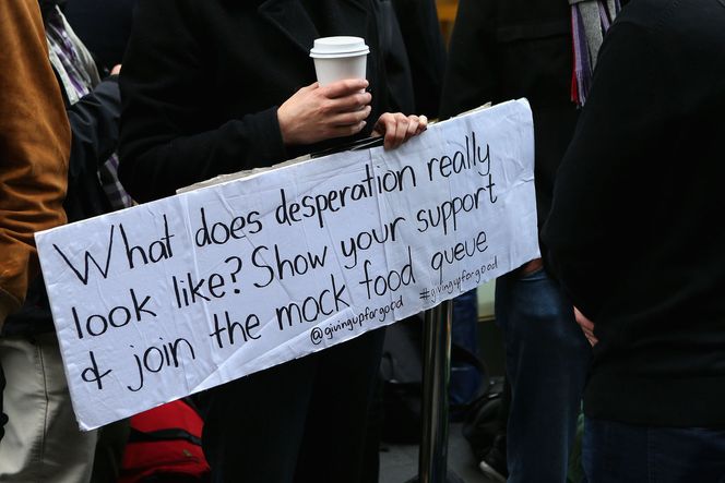 "Hvordan ser desperasjon egentlig ut? Vis din støtte og delta i denne liksom-matkøen" sto det på en plakat i Sydney. Der hadde hundrevis av Apple-kunder stilt seg opp i håp om å sikre seg et eksemplar. En av dem var Steve Wozniak - en av Apples gründere. Bilde: Cameron Spencer/Getty Images/All Over Press