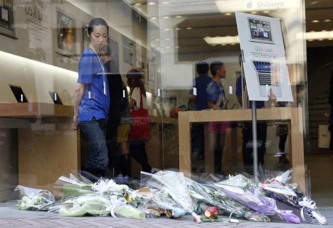 Folk legger ned blomster utenfor Apple Stores verden over. Her fra en av butikkene i Tokyo. Bilde: Reuters