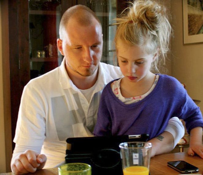 Angelina bruker nettbrett. Her sammen med stefaren, Marius Mathisen. Bilde: Privat