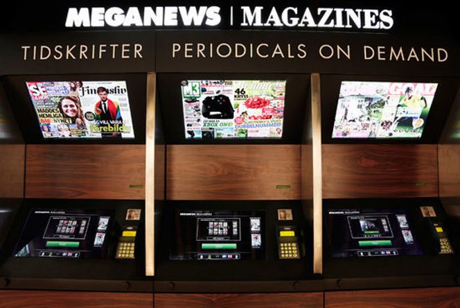 Brukerterminalene er utformet med tanke på å gjøre det enkelt å se seg godt om før man bestemmer seg. Når man har betalt, leveres bladet i skuffen under den øverste skjermen. Bilde: Meganews