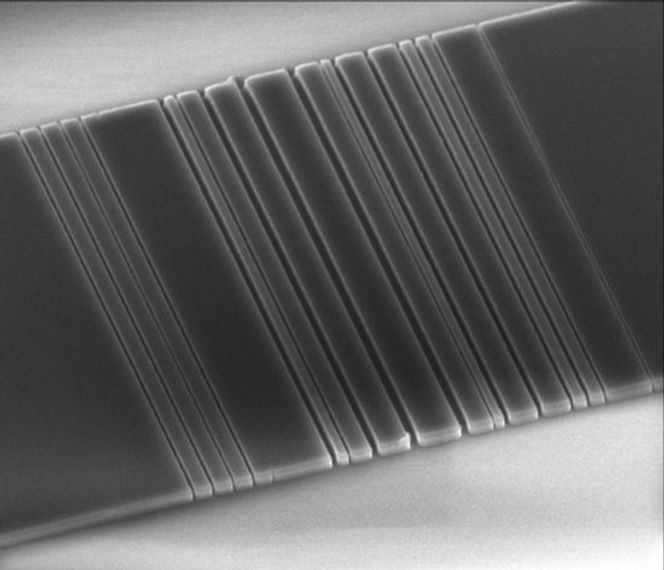 Fotografiet viser den optiske linken som forskerne ved Stanford University har designet ved hjelp av automatisert programvare. Som bildet viser, har den vesle silisiumbiten et mønster som kan minne om en strekkode. Den anses av forskerne som et skritt videre på veien mot datamaskiner hvor komponentene er knyttet samme ved hjelp av lys i stedet for kobbertråder. Bilde: Stanford University