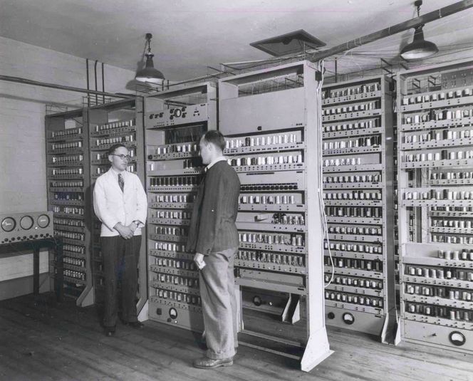 Maurice Wilkes ledet teamet som konstruerte EDSAC. Her står han foran EDSAC sammen med en forskerkollega, Bill Renwick, som også deltok i prosjektet. Bilde: Computer Laboratory, University of Cambridge (CC BY 2.0)