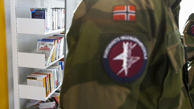 Vi kunne ikke unngå å legge merke til «The Hacker's Handbook», «Global Information Warfare» og tilsvarende titler i bokhyllene bak oberstløytnant Roger Johnsen. Bilde: Per Ervland