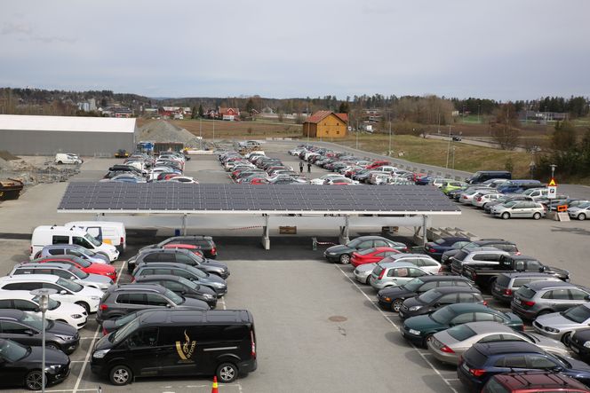 Solcellene har produsert strøm i to uker, men torsdag er første dagen ansatte kan lade elbilen mens de står parkert under de dobbeltsidige solcellene hos Asko i Vestby. Foto: Jannicke Nilsen