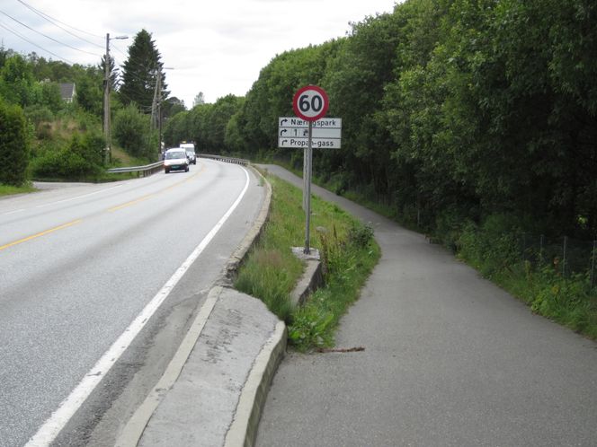 Eksempel 3. E 39 i Bergen kommune. Lav støpekant i yttersving der det er en bratt skråning og gangveg på utsiden av europavegen. Dårlig sikret rekkverksende. Foto: Statens Vegvesen