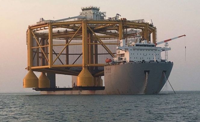 Ocean Farm1 måler 110 meter i diameter og stikker godt ut på sidene fra 43,6 meter brede og 182 meter lange Hua Hai Long.. Foto: Salmar