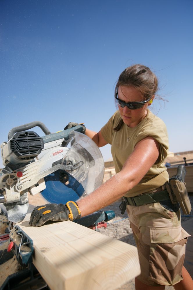 Her hjelper en som jobber i CIS-TG-enheten til med byggingen av Camp Midgard. Foto:  Camilla Brevik Hågensen - Forsvaret