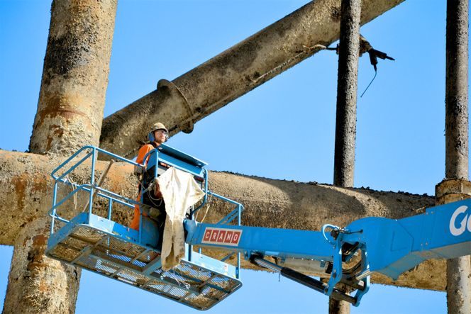 Høytrykksspyling: Fra ei arbeidskorg mer enn 80 meter over bakken arbeider ansatte hos underleverandøren JWS-gruppen med å spyle løs begroing fra stålunderstell som skal parteres og hogges opp.  (Foto: Thomas Førde)