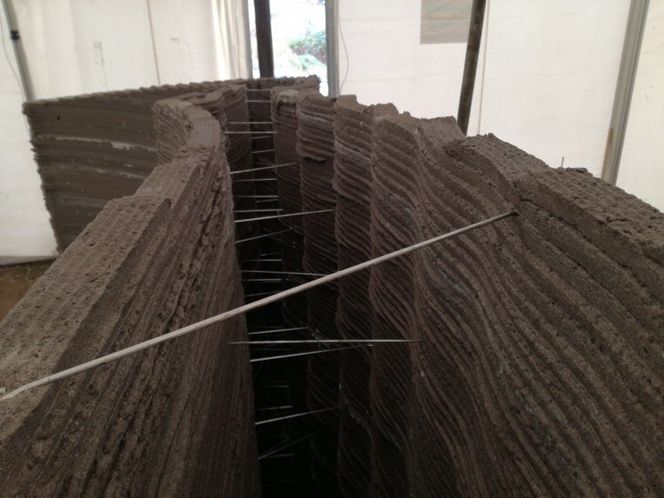 Vegger med bølgeformer og varierende høyde er enklere å lage med en 3D-skriver enn med tradisjonelle støpeformer. Men helt lett er det fremdeles ikke. For eksempel betyr buene at hulrommet mellom for- og bakmur varierer i tykkelse. Derfor må lengden av alle murbinderne tilpasses manuelt. Og siden betongoppskriften er optimert til at det tar 24 minutter å skrive ut et lag, er det svært lang ventetid i slutten av utskriftsprosessen, hvor det på grunn av de skrånende veggene skrives ut stadig kortere lag. (Foto: Ulrik Andersen)