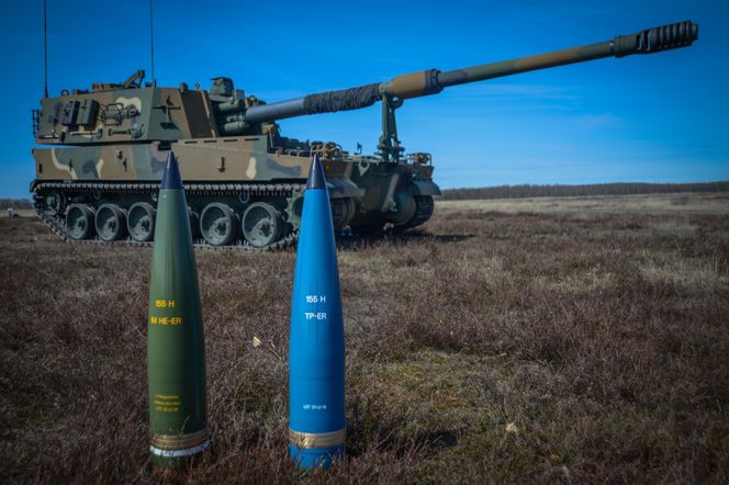 Den nye IM HE-ER-granaten og en treningsversjon (blå) foran ei K9-vogn. Finland er første bruker av ammunisjonen i det koreanskbygde artilleriet som også er en kandidat i Norge. Bilde: Nammo