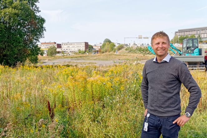 Prosjektsjef Per Roger Johansen viser hvor Livsvitenskapsbygget kommer, på sydsiden av Ring 3 og Rikshospitalet, mellom Ullevål Stadion og Forskningsparken. Under dagens blomstereng ligger mye kvikkleire som krever stabilisering og overvåking. Som en del av prosjektet skal Gaustadbekken bringes opp i dagen igjen og bidra til trivsel. Foto: Joachim Seehusen