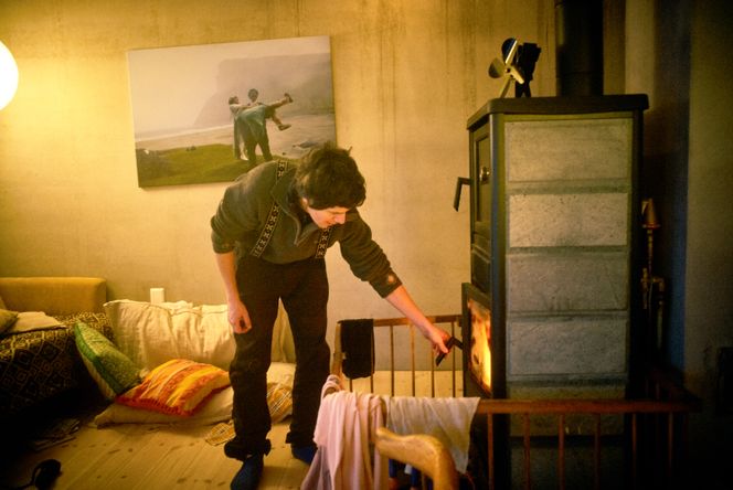 All varmen til huset kommer fra denne vedovnen. Her sørger Inge Tamburaci Wegge for at det brenner godt. Foto: Eivind H. Natvig