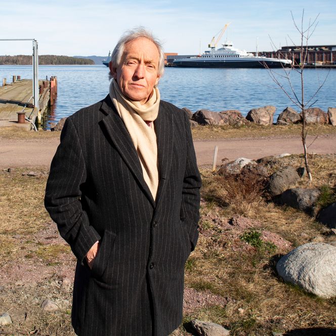 Hans Olav Tangen på stranda hvor bryggene med de flytende boligene skal ligge. «Mosseferja» i bakgrunnen. Foto: Knut Bjørheim