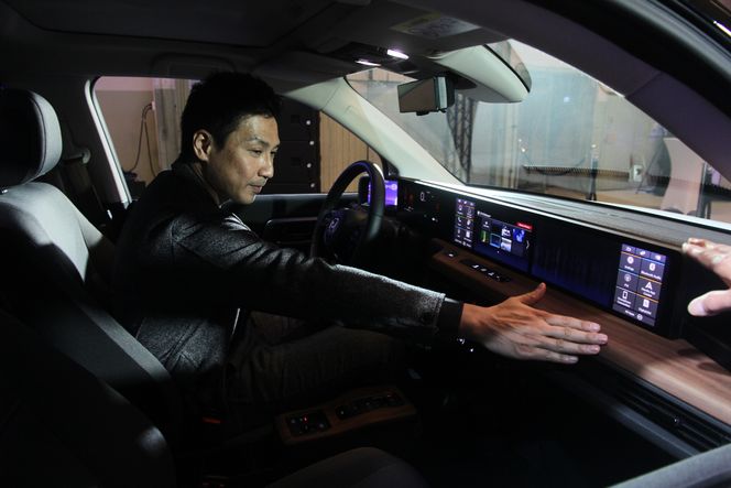  Akinori Myoui viser fram det han er mest stolt av hva gjelder interiøret i Honda e: Det horisontalt orienterte designet som kulminerer med skjermene som strekker seg over hele bredden av bilen i dashbordet. Foto:   Ole Petter Pedersen